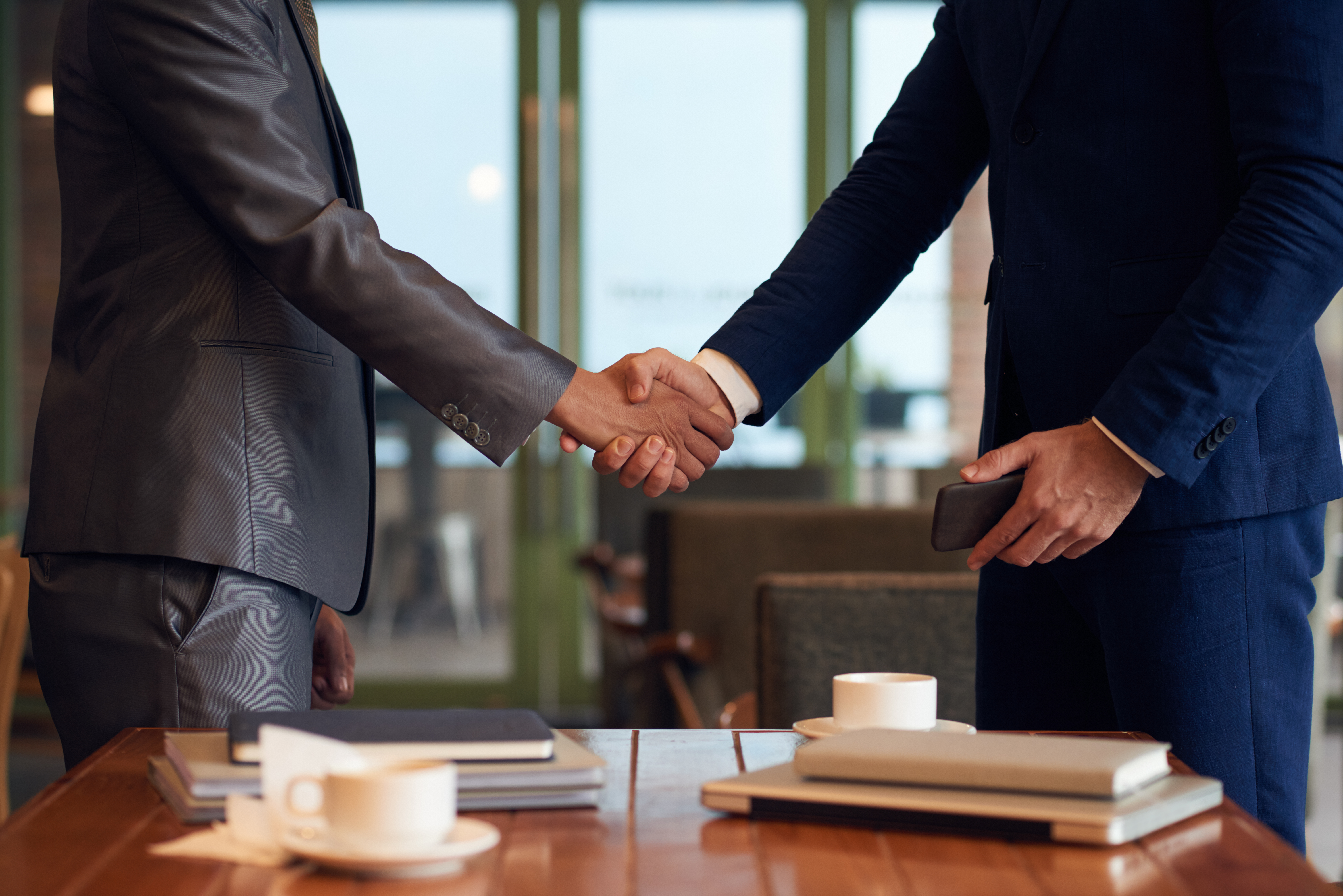 mid section two unrecognizable businessmen shaking hands finalize deal